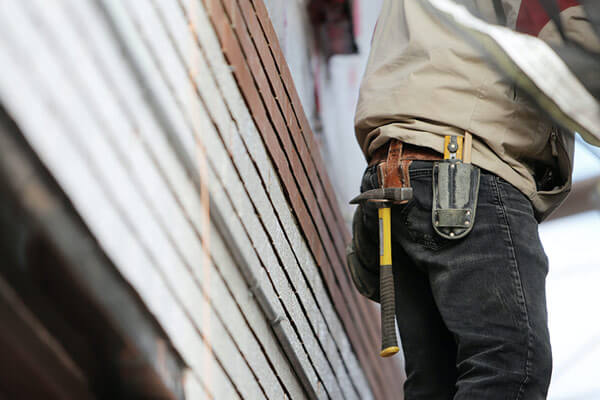 Commercial roofer hammering roof